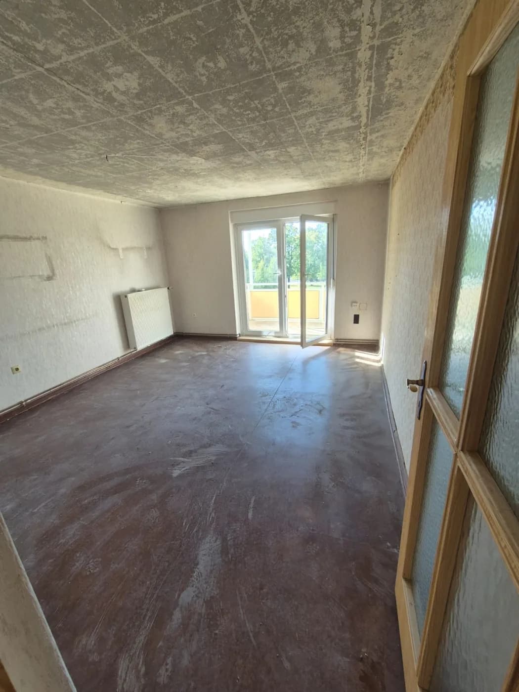 Raum im Rohzustand nach der Entrümpelung, abgekratzte Decke und Estrich