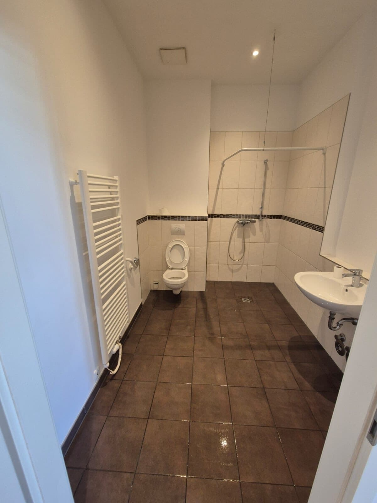 Dasselbe Badezimmer leer und besenrein nach der Endreinigung, freier Boden, WC und Dusche sauber